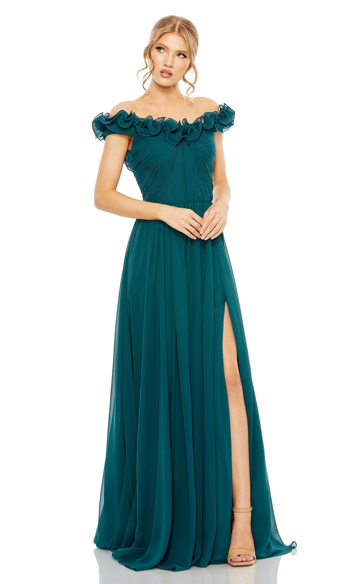 A woman stands with her hands clasped in front, showcasing the elegant Long Formal Dress 11591 by Mac Duggal—an off-the-shoulder teal gown with a ruffled neckline, a thigh-high slit, and a graceful A-line silhouette.